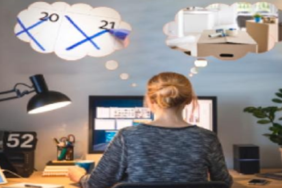 Woman at desk thinking about work travel plans