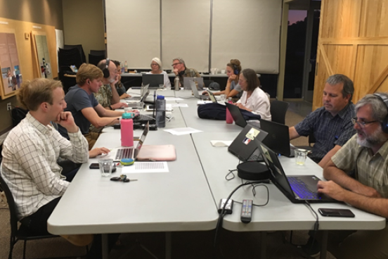 Students, faculty and citizens working around a table