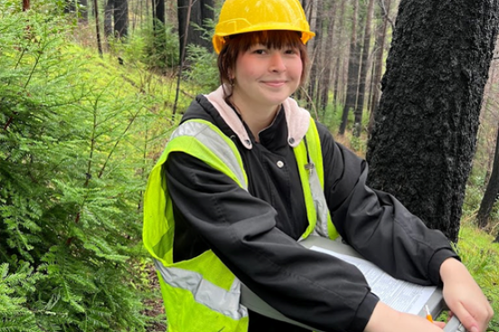 Student with clipboard in forest