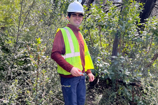 Student standing in forest
