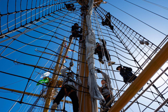 Students climbing a sailing mast