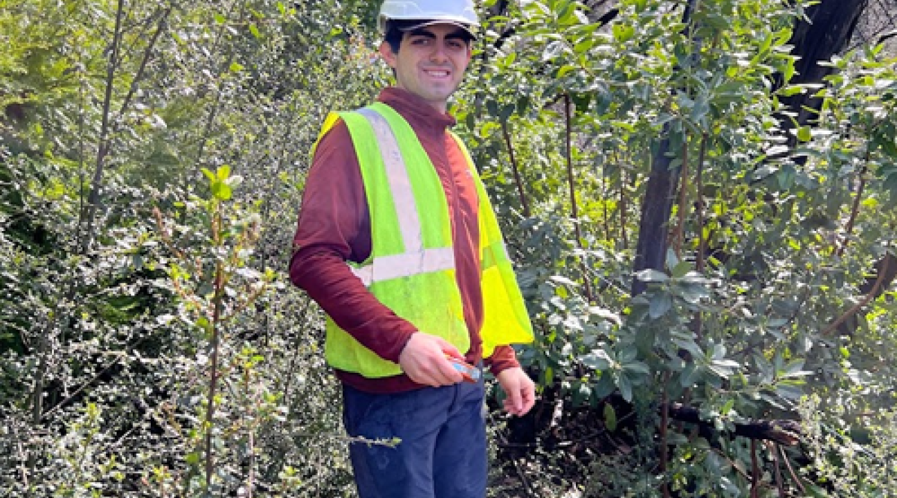 Student standing in forest