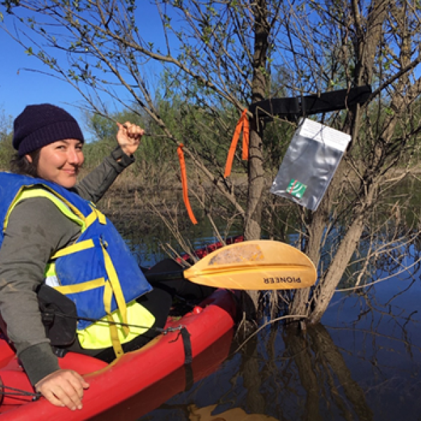 Student in kayak in a wetland with audio recorder in view