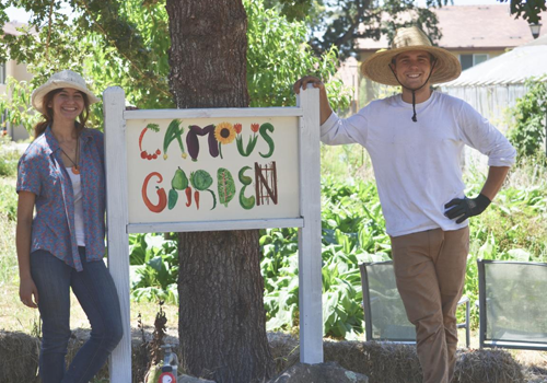 Students standing next to Campus Garden sign