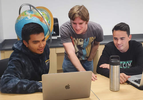 Three students working together on computers