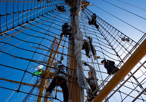 Students climbing a sailing mast